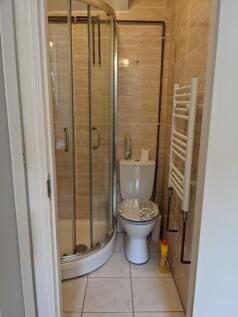 A tidy bathroom featuring a shower, toilet, and...
