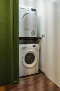A compact laundry space featuring stacked washi...