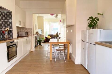 Bright modern galley-style kitchen with white c...