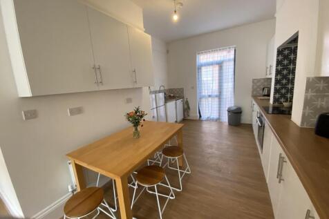 Bright, modern kitchen with wood-effect floorin...