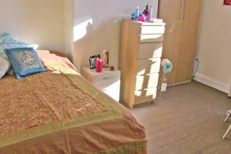 Bright, simply furnished bedroom with a comfort...