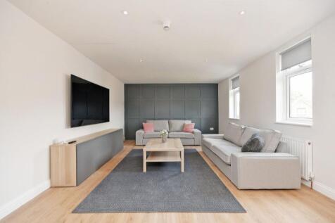 A spacious, modern living room featuring two co...
