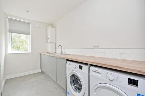 A modern, minimalist kitchen with ample counter...