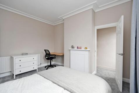 A well-maintained, bright bedroom featuring a n...