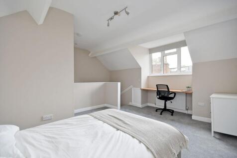 A bright and clean bedroom featuring a comforta...