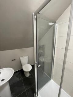 Modern bathroom featuring a shower enclosure, a...
