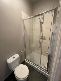 A clean and modern bathroom featuring a glass-e...