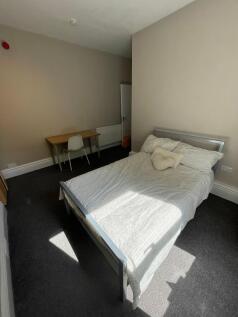 A bright and tidy bedroom with a comfortable do...