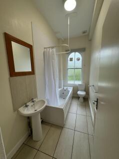 A well-maintained bathroom featuring a bathtub ...