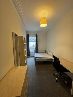 A well-lit single bedroom featuring a single be...