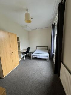 A simple, tidy single bedroom featuring a wardr...