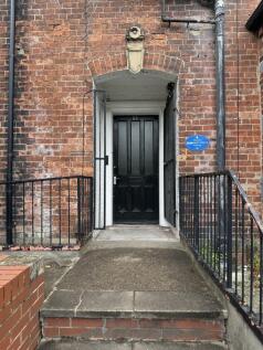 Photograph of the front entrance of a brick-bui...