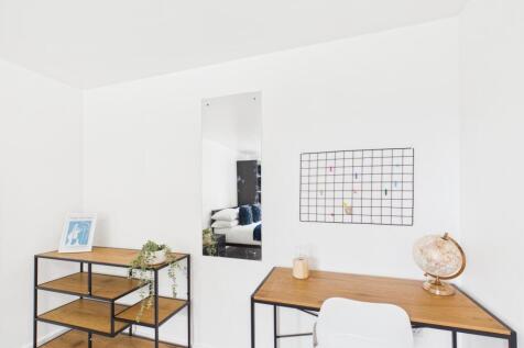 Bright, minimal workspace with a wooden desk, c...