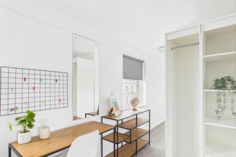 Bright, modern bedroom with a neat study area, ...