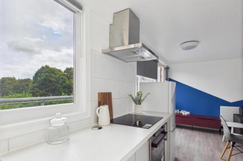 Bright modern kitchen with white countertops, i...