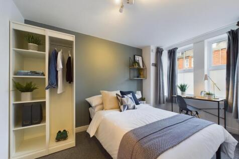 A bright and comfortable bedroom featuring a ne...