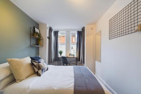 A bright and inviting master bedroom featuring ...