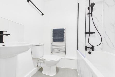 Bright modern bathroom with a white suite, bath...