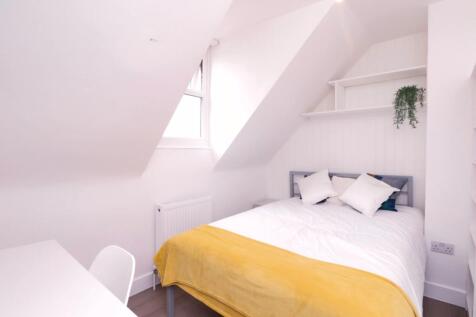 A bright and spacious double bedroom with a sty...