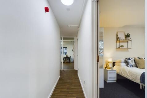 A well-maintained hallway leading to a cozy liv...