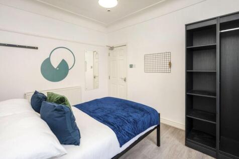 A spacious and stylish double bedroom featuring...