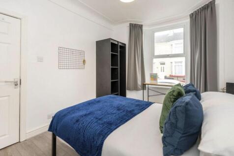 A bright and clean double bedroom featuring mod...