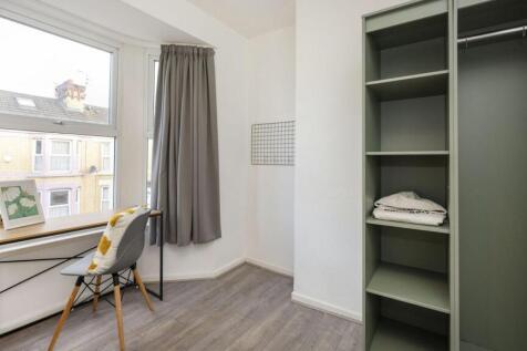 A bright and tidy double bedroom featuring a st...