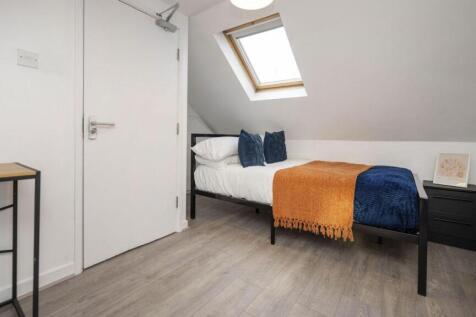 A bright and tidy single bedroom with modern de...