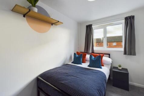 A bright and inviting double bedroom with moder...