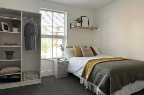 A bright and inviting double bedroom with styli...