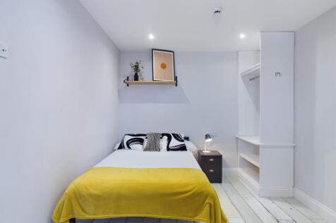 A bright and tidy bedroom featuring a comfortab...