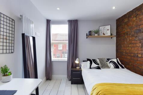 A bright and inviting bedroom featuring a comfo...