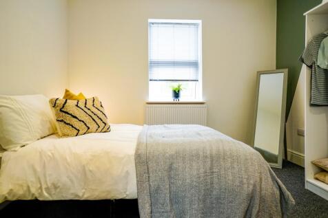 A bright and inviting bedroom featuring a comfo...