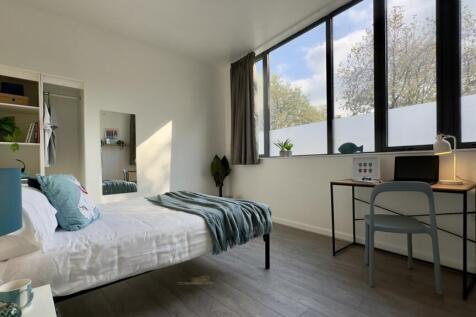 A bright and modern double bedroom featuring la...