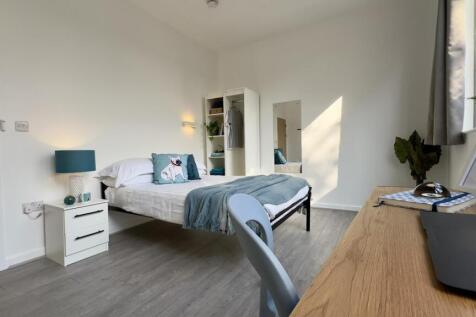 A spacious and bright double bedroom featuring ...