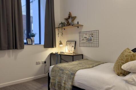 A bright and tidy double bedroom featuring mode...