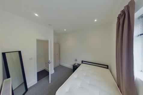 A bright, tidy bedroom with a comfortable bed a...