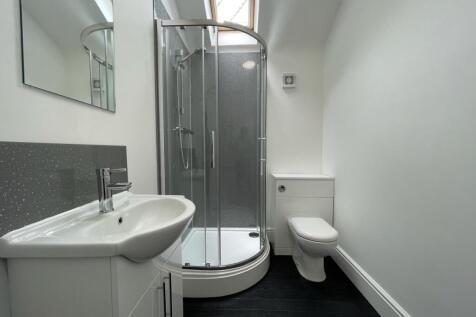 A modern and tidy bathroom featuring a walk-in ...