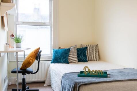 Bright, neatly styled bedroom with a comfortabl...