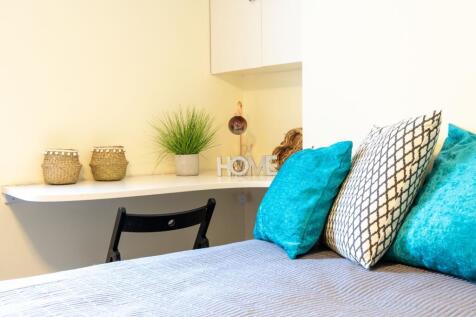 Bright, neatly styled bedroom corner with a com...
