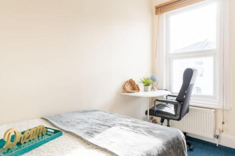 Bright, neutral bedroom with a comfortable bed,...