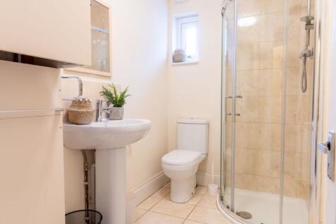 Bright, modern bathroom with a curved glass sho...