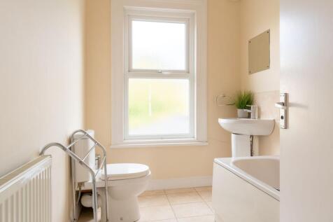 Bright, well-maintained bathroom with a frosted...