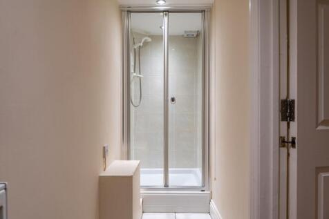 Neat enclosed shower cubicle with sliding glass...