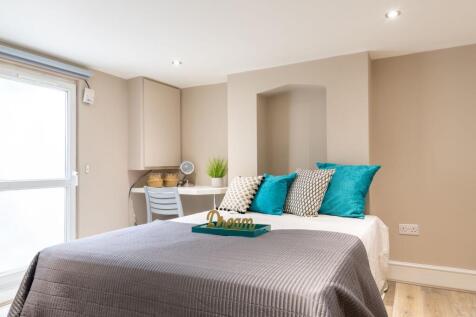 Bright, neatly styled bedroom with a comfortabl...