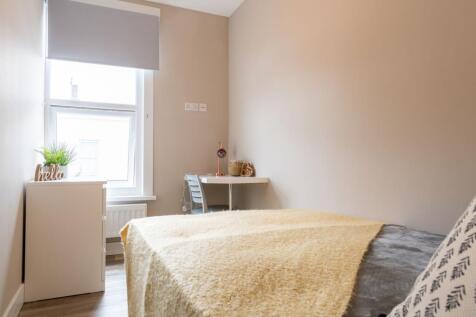 Bright, neatly styled bedroom with a comfortabl...