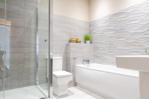 Modern, well-lit bathroom with a separate glass...