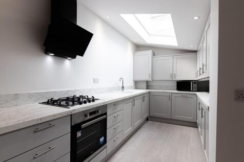 Bright modern galley kitchen with marble-effect...