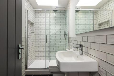 Bright, modern bathroom with full walk-in glass...