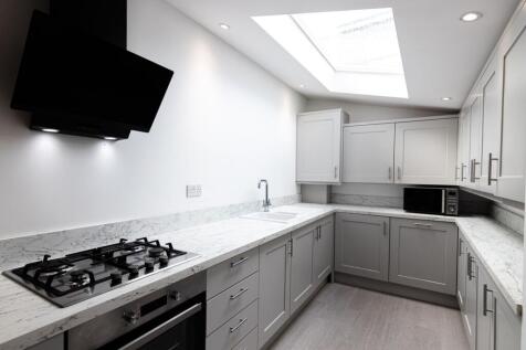 Bright, modern galley kitchen with marble-effec...